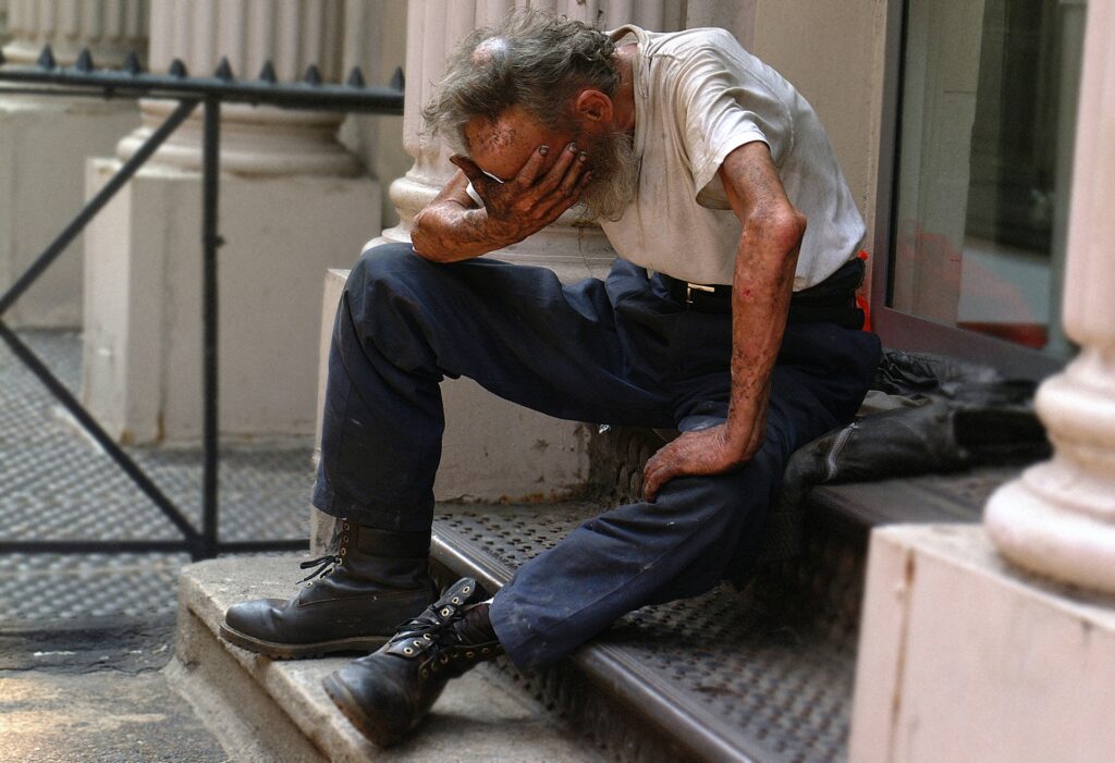 man sitting on stair with face in hand 